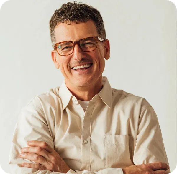 Homem sorrindo com os braços cruzados